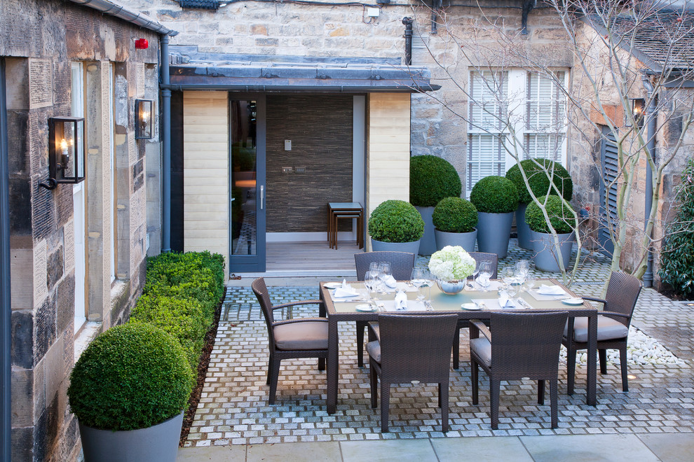 Mid-sized transitional courtyard garden in Other with natural stone pavers.