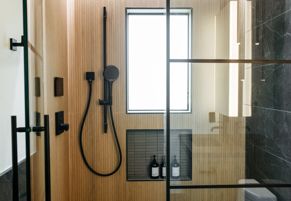 Modernes Duschbad mit Duschnische, braunen Fliesen, Fliesen in Holzoptik, weißer Wandfarbe, Falttür-Duschabtrennung und Wandnische in Houston