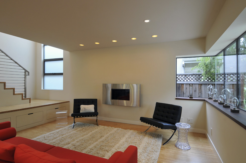 Design ideas for a contemporary enclosed living room in San Francisco with beige walls, no tv, bamboo floors, a standard fireplace and a metal fireplace surround.