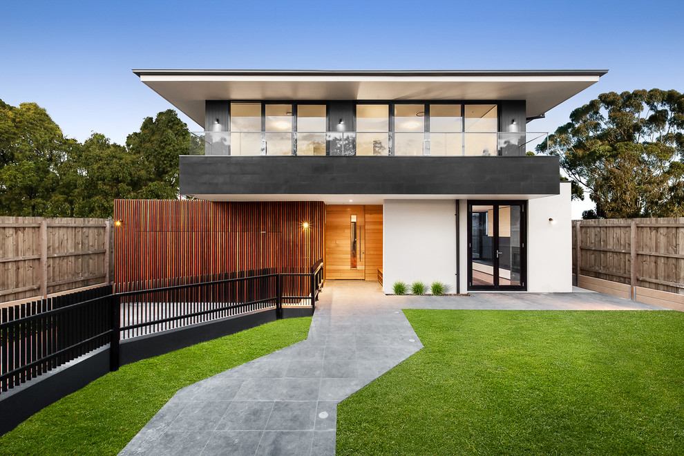 Photo of a contemporary two-storey white exterior in Melbourne with a hip roof.