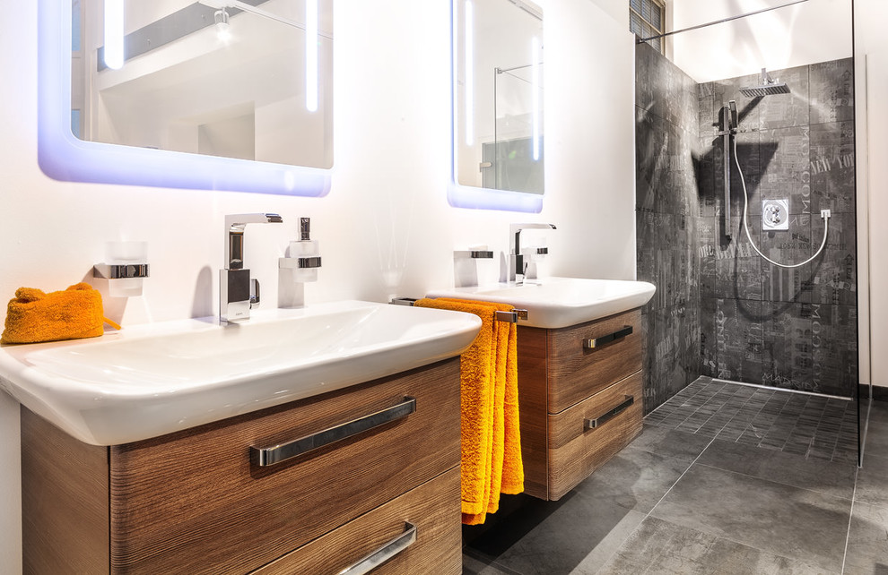 Photo of a contemporary bathroom in Munich with a vessel sink, flat-panel cabinets, medium wood cabinets, an open shower, black tile and an open shower.