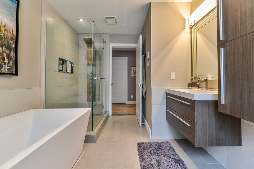 Inspiration for a large modern bathroom in Montreal with an integrated sink, flat-panel cabinets, dark wood cabinets, quartzite benchtops, a freestanding tub, a curbless shower, a one-piece toilet, beige tile, porcelain tile, beige walls and porcelain floors.