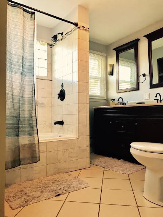 Tub/shower combo - mid-sized transitional gray tile, white tile and ceramic tile ceramic tile and beige floor tub/shower combo idea in Phoenix with black cabinets, beige walls, granite countertops and an integrated sink