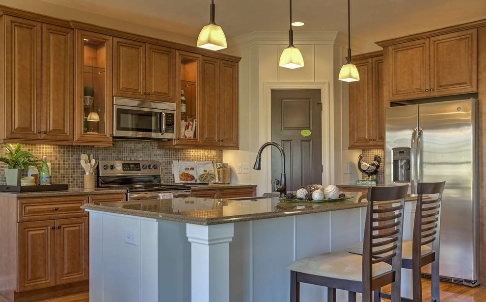 Example of a l-shaped kitchen design in Omaha with raised-panel cabinets, medium tone wood cabinets, granite countertops and an island