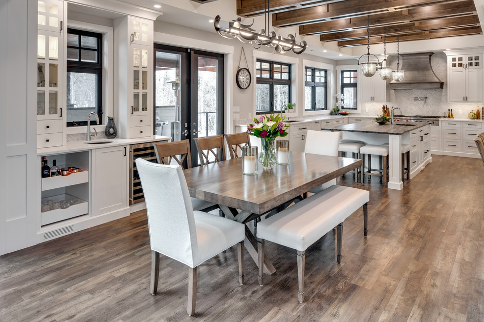 Example of a huge transitional u-shaped dark wood floor and brown floor kitchen design in Calgary with an undermount sink, shaker cabinets, white cabinets, marble countertops, white backsplash, marble backsplash, stainless steel appliances, an island and white countertops