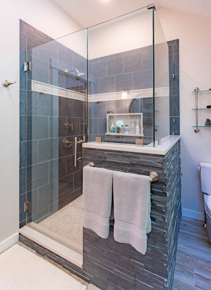 Uriges Badezimmer mit Eckdusche, Porzellanfliesen, grauer Wandfarbe, Porzellan-Bodenfliesen, grauem Boden und Falttür-Duschabtrennung in Burlington