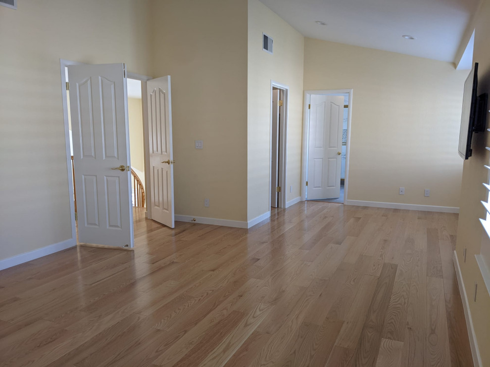 Esempio di un soggiorno con sala formale, pavimento in legno verniciato, TV a parete, pavimento arancione e soffitto a volta