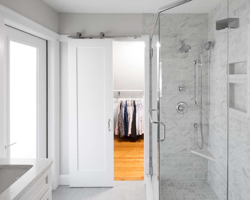 Design ideas for a mid-sized transitional 3/4 bathroom in Boston with shaker cabinets, white cabinets, a corner shower, a two-piece toilet, gray tile, white tile, marble, grey walls, vinyl floors, an undermount sink, quartzite benchtops, grey floor and a hinged shower door.