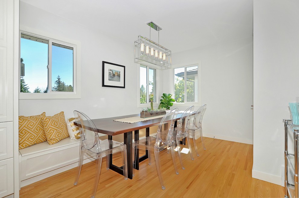 This is an example of a mid-sized transitional open plan dining in Calgary with white walls and light hardwood floors.
