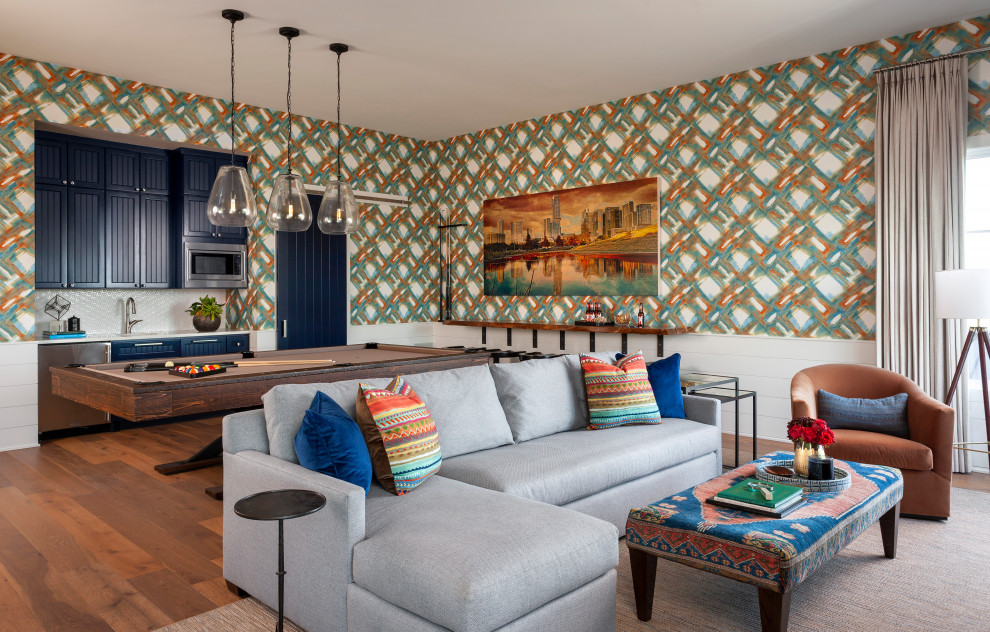 Imagen de sala de juegos en casa abierta tradicional renovada extra grande con paredes multicolor, televisor colgado en la pared, suelo marrón y papel pintado
