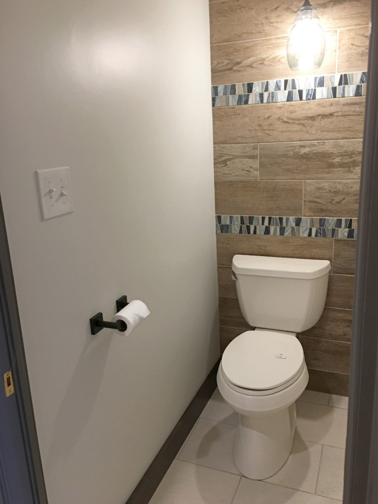 This is an example of a mid-sized transitional powder room in Denver with recessed-panel cabinets, dark wood cabinets, an undermount sink, engineered quartz benchtops and white benchtops.