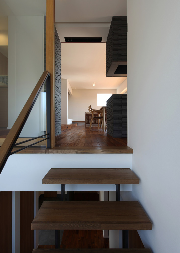 This is an example of a large modern wood u-shaped mixed railing staircase in Other with open risers.