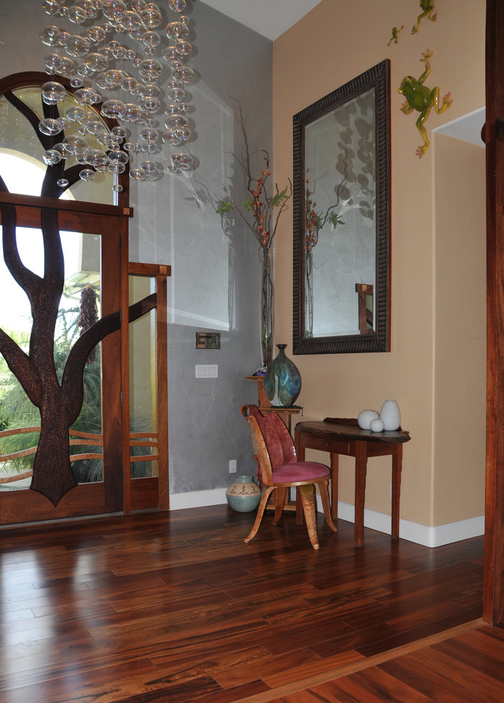 Large eclectic dark wood floor foyer photo with multicolored walls and a glass front door