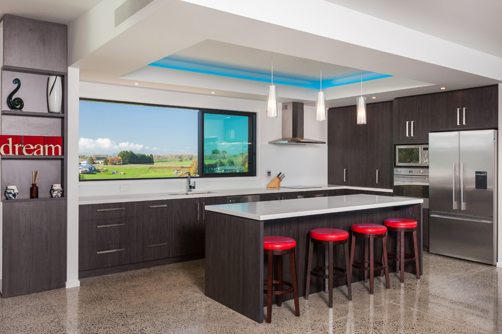 Photo of a contemporary l-shaped kitchen in Hamilton with an undermount sink, flat-panel cabinets, dark wood cabinets, stainless steel appliances, concrete floors and with island.