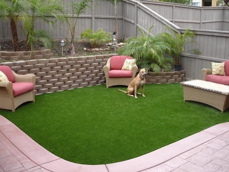 Photo of a small modern backyard partial sun formal garden for summer in Tampa with a retaining wall and concrete pavers.