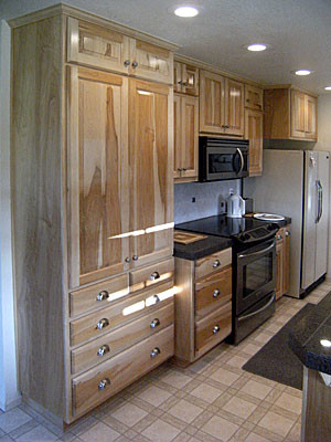 Inspiration for a galley white floor kitchen remodel with raised-panel cabinets, stainless steel appliances, a peninsula and gray countertops
