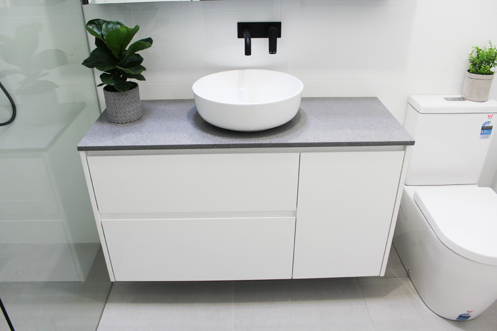 Design ideas for a small modern 3/4 bathroom in Perth with flat-panel cabinets, white cabinets, an open shower, a one-piece toilet, gray tile, porcelain tile, grey walls, porcelain floors, a vessel sink, solid surface benchtops, grey floor, an open shower and grey benchtops.
