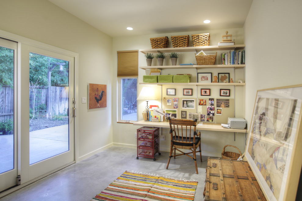 Mid-sized contemporary home office in Sacramento with concrete floors, white walls, no fireplace, a built-in desk and grey floor.