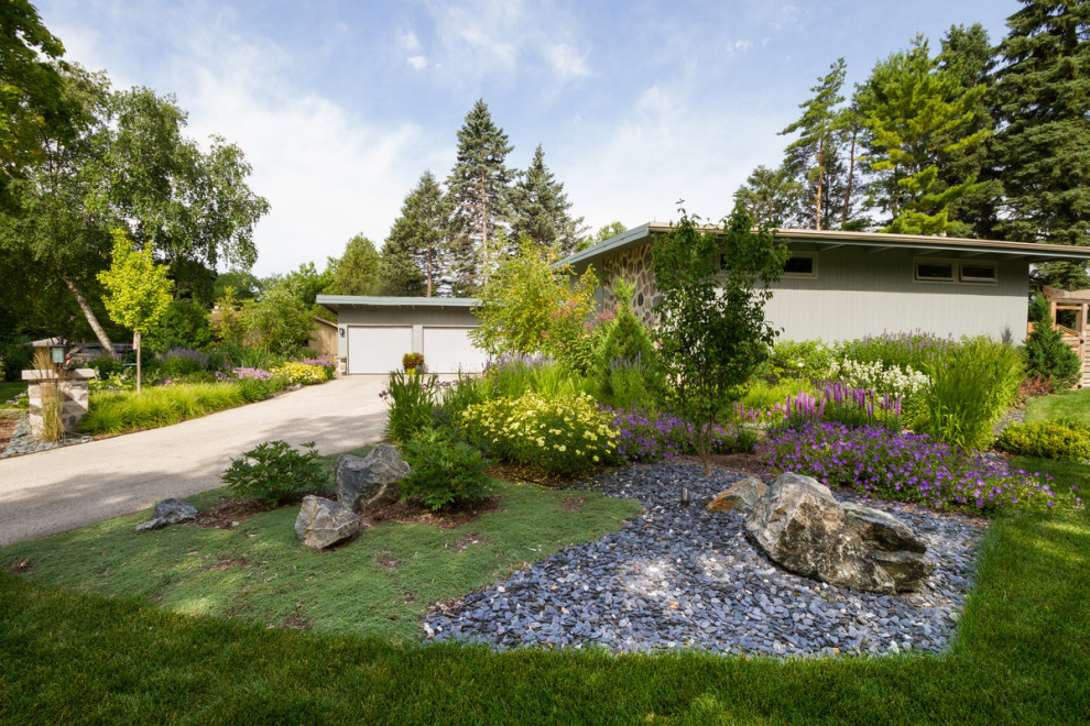 Inspiration for a mid-sized modern front yard partial sun driveway for summer with gravel.
