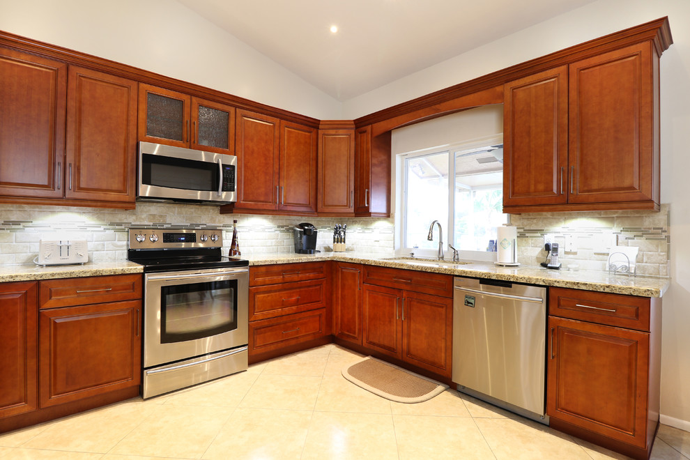 Mid-sized transitional u-shaped porcelain tile eat-in kitchen photo in Miami with an undermount sink, raised-panel cabinets, medium tone wood cabinets, granite countertops, beige backsplash, mosaic tile backsplash, stainless steel appliances and no island