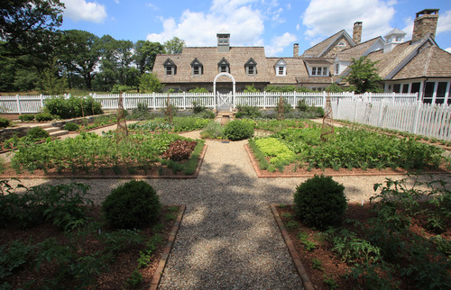 Here is a massive vegetable garden, over a large yard. The sections are spread wide apart, and the ample space is used to make maintaining the garden easy and manageable.