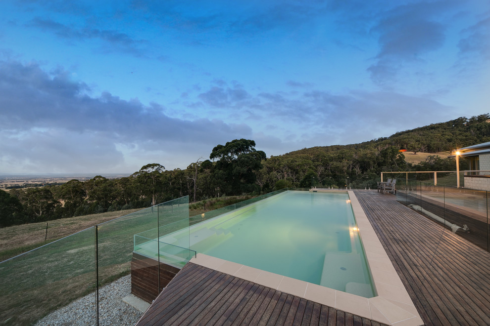 Photo of a large modern backyard rectangular infinity pool in Melbourne.