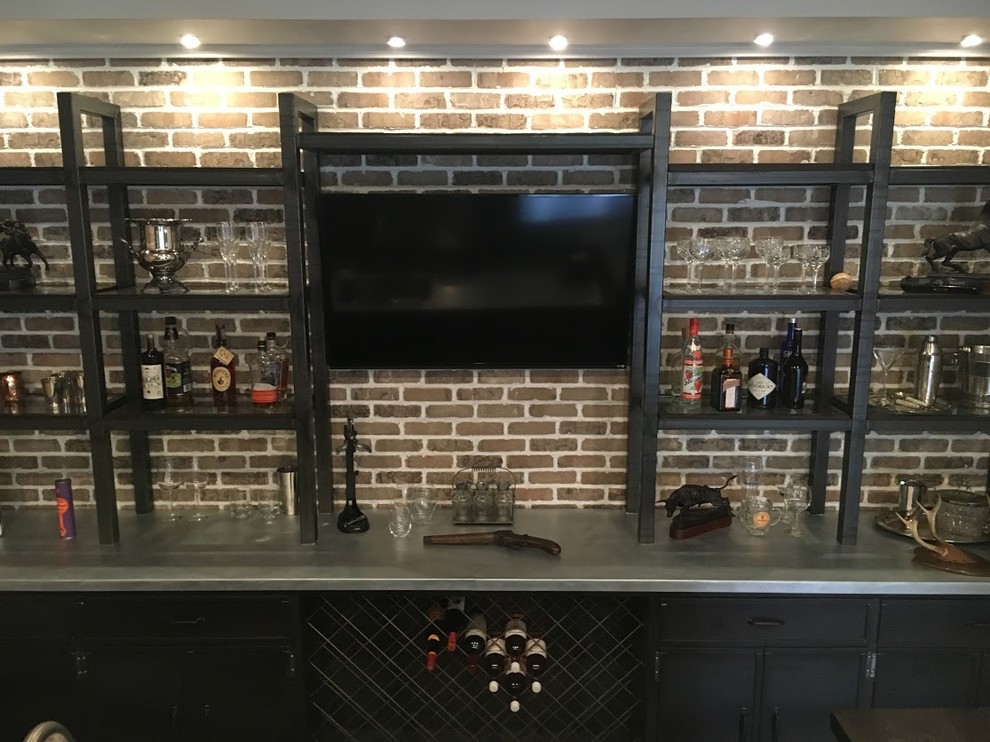 Mid-sized industrial galley seated home bar in Atlanta with a drop-in sink, recessed-panel cabinets, black cabinets, concrete benchtops, brown splashback, brick splashback, dark hardwood floors and brown floor.