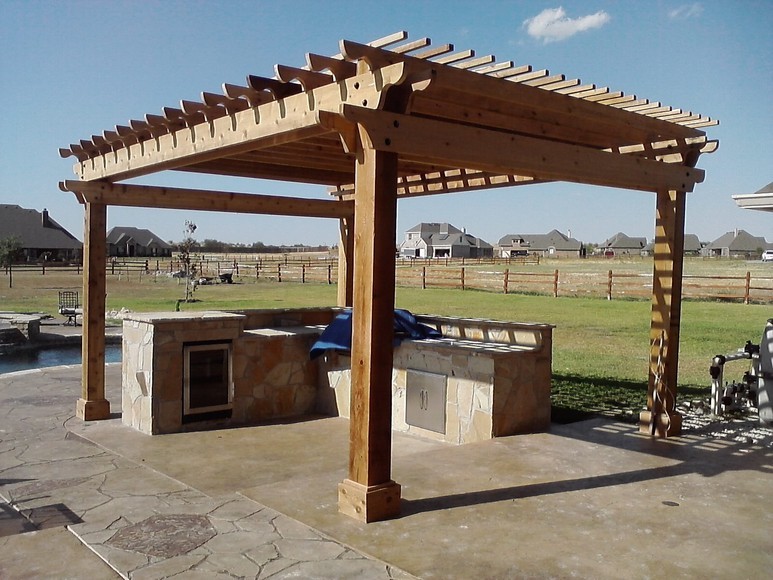 Example of a large classic backyard patio kitchen design in Dallas with a pergola