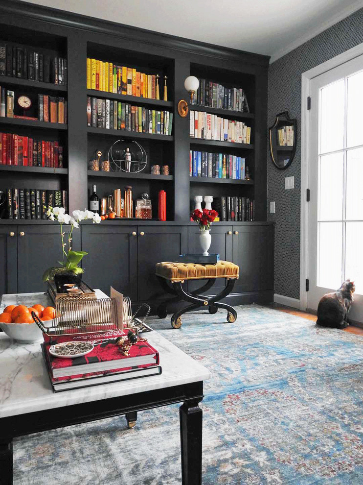 Inspiration for a mid-sized traditional home office in New York with a library, grey walls, medium hardwood floors, no fireplace and brown floor.