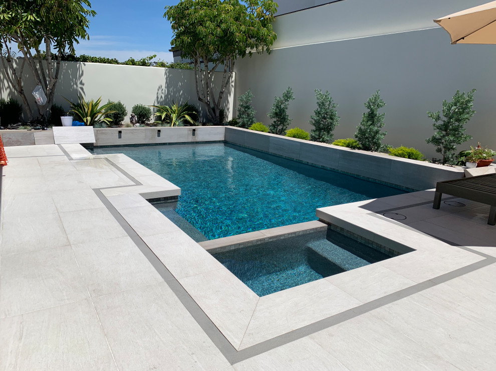 Design ideas for a coastal custom shaped swimming pool in Orange County with tiled flooring.