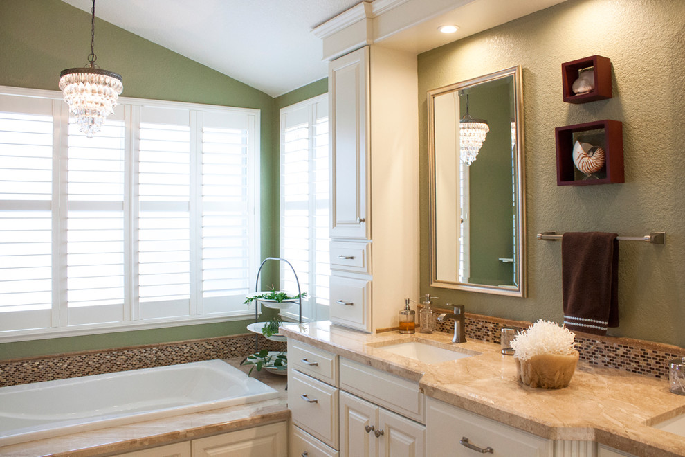 Drop-in bathtub - large transitional master multicolored tile and mosaic tile travertine floor drop-in bathtub idea with raised-panel cabinets, white cabinets, a one-piece toilet, green walls, an undermount sink and marble countertops