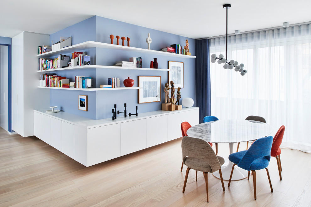 Esempio di una sala da pranzo minimalista con pareti blu, parquet chiaro e pavimento beige