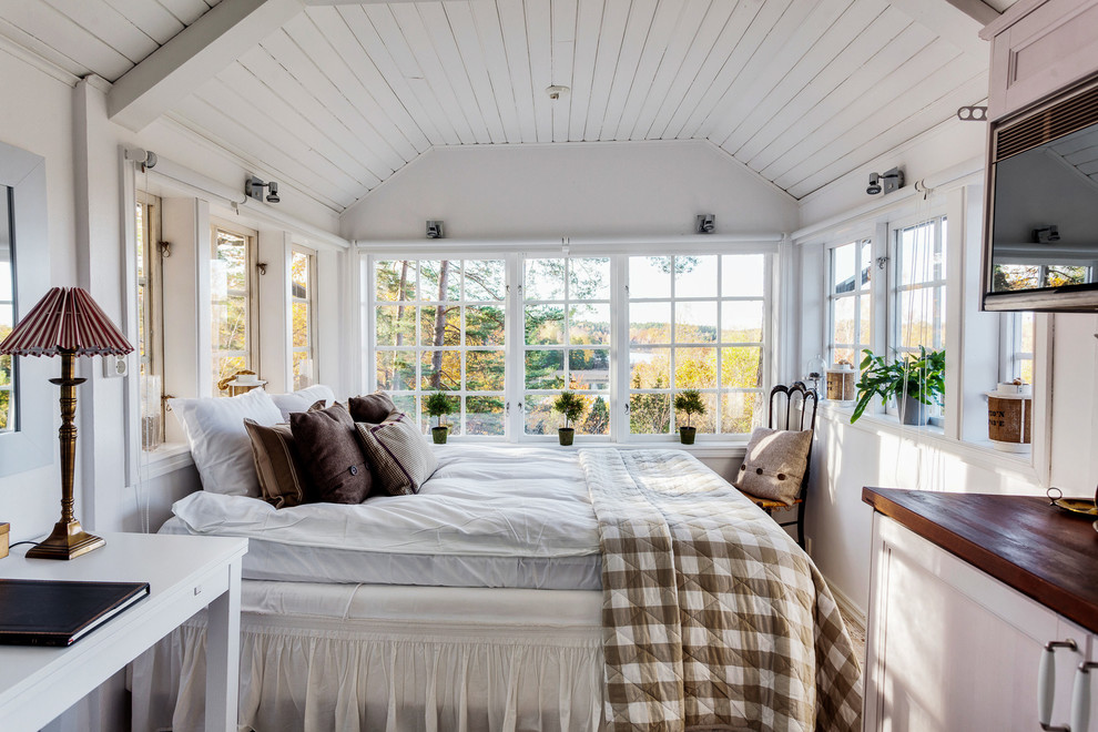 This is an example of a small country master bedroom in Stockholm with white walls and no fireplace.