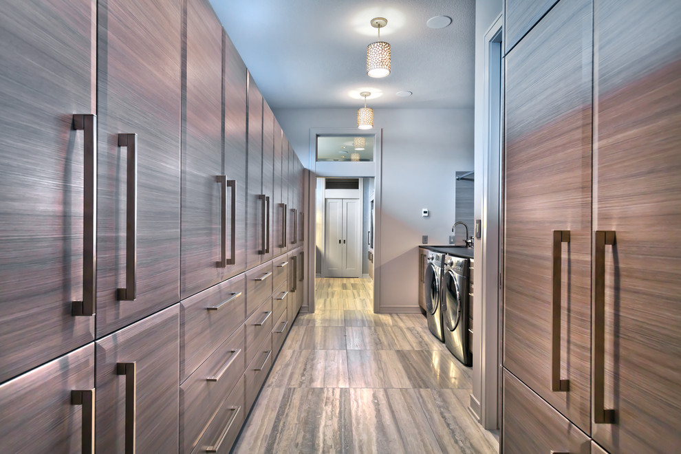 Expansive contemporary gender-neutral walk-in wardrobe in Minneapolis with flat-panel cabinets, grey cabinets, travertine floors and grey floor.