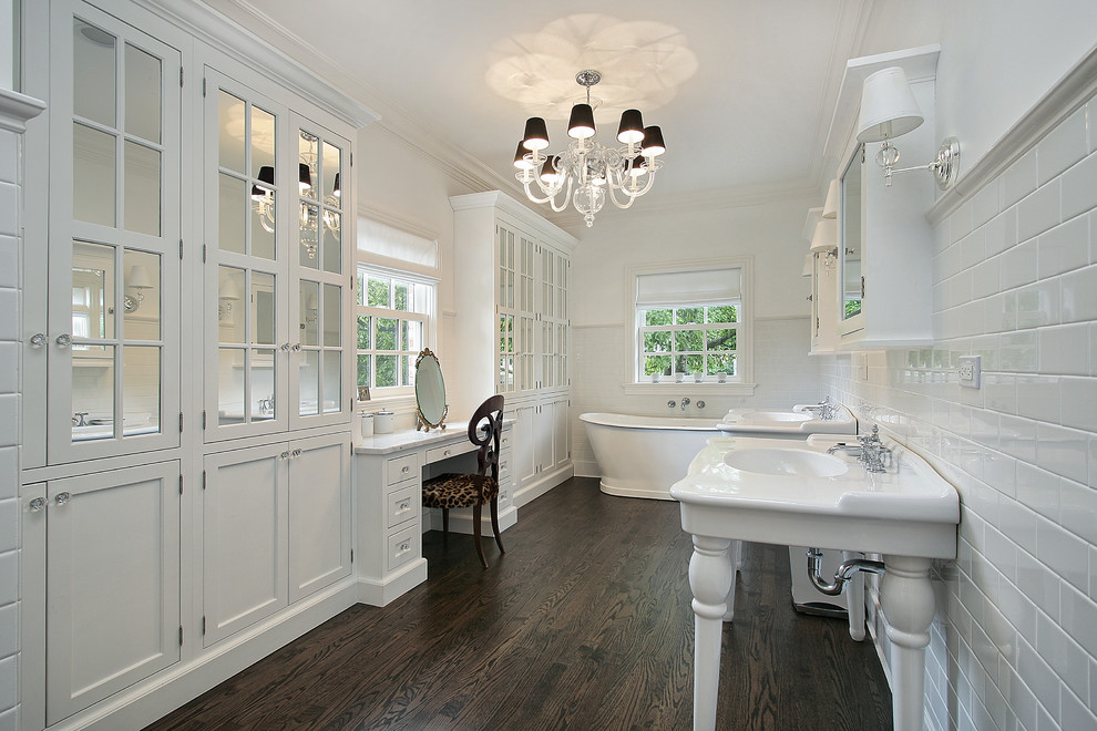 Inspiration for a mid-sized transitional master bathroom in Atlanta with a pedestal sink, beaded inset cabinets, white cabinets, marble benchtops, a freestanding tub, a corner shower, a two-piece toilet, white tile, subway tile, white walls and dark hardwood floors.