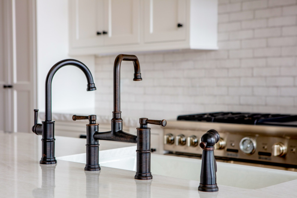 Eat-in kitchen - large rustic l-shaped light wood floor and beige floor eat-in kitchen idea in Toronto with a farmhouse sink, shaker cabinets, white cabinets, quartz countertops, white backsplash, subway tile backsplash, paneled appliances, an island and white countertops