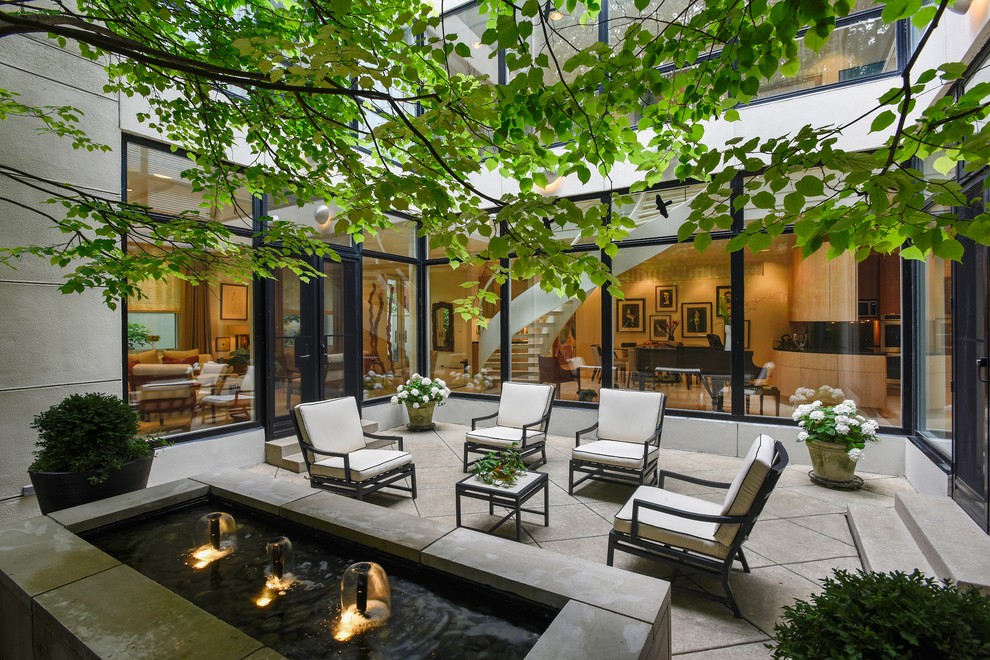 Inspiration for a contemporary courtyard patio in Chicago with a water feature and no cover.