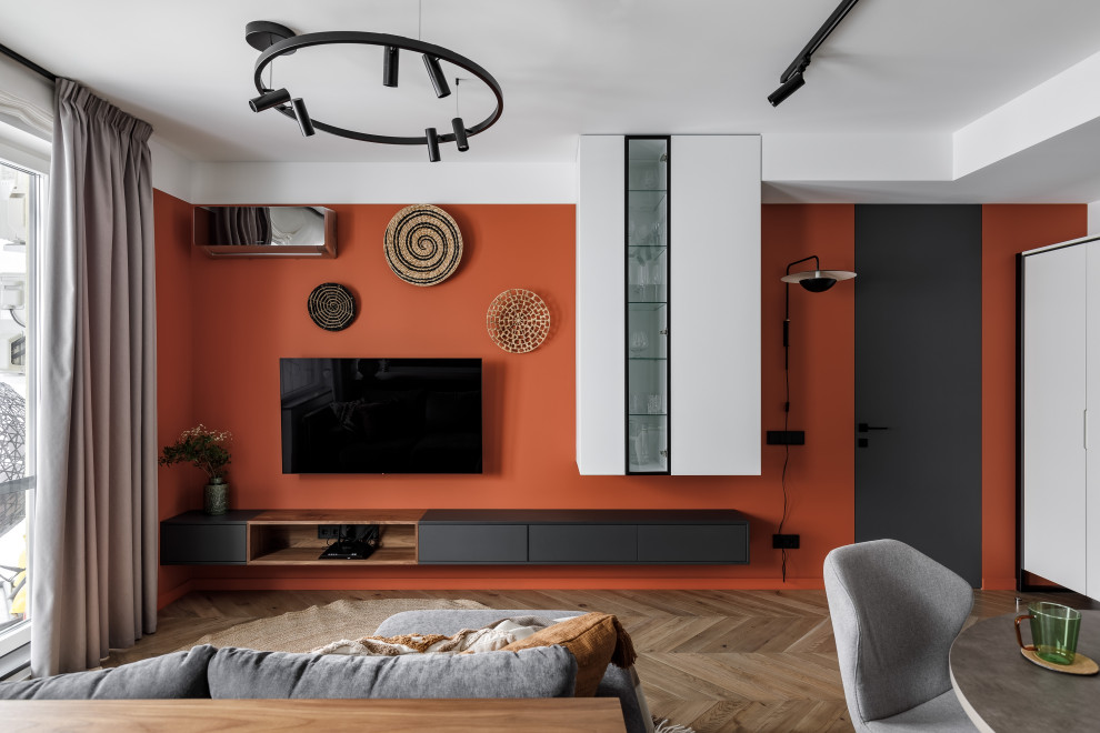 Ejemplo de salón contemporáneo de tamaño medio con paredes multicolor, suelo de madera en tonos medios, televisor colgado en la pared y suelo marrón