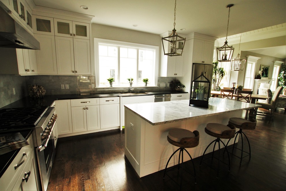 Eat-in kitchen - large transitional l-shaped dark wood floor and brown floor eat-in kitchen idea in Boston with an undermount sink, shaker cabinets, white cabinets, granite countertops, beige backsplash, marble backsplash, stainless steel appliances and an island