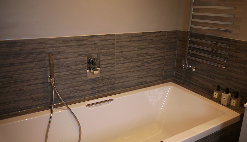 This is an example of a small modern master bathroom in Surrey with brown walls and a wall-mount sink.