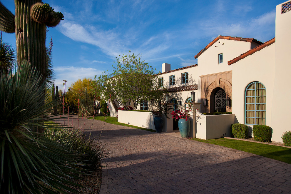 This is an example of a large mediterranean two-storey stucco white exterior in Phoenix with a gable roof.