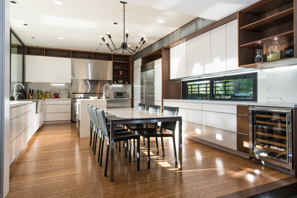 Inspiration for an expansive contemporary u-shaped eat-in kitchen in Orange County with flat-panel cabinets, white cabinets, stainless steel appliances, with island, bamboo floors, metallic splashback and a farmhouse sink.