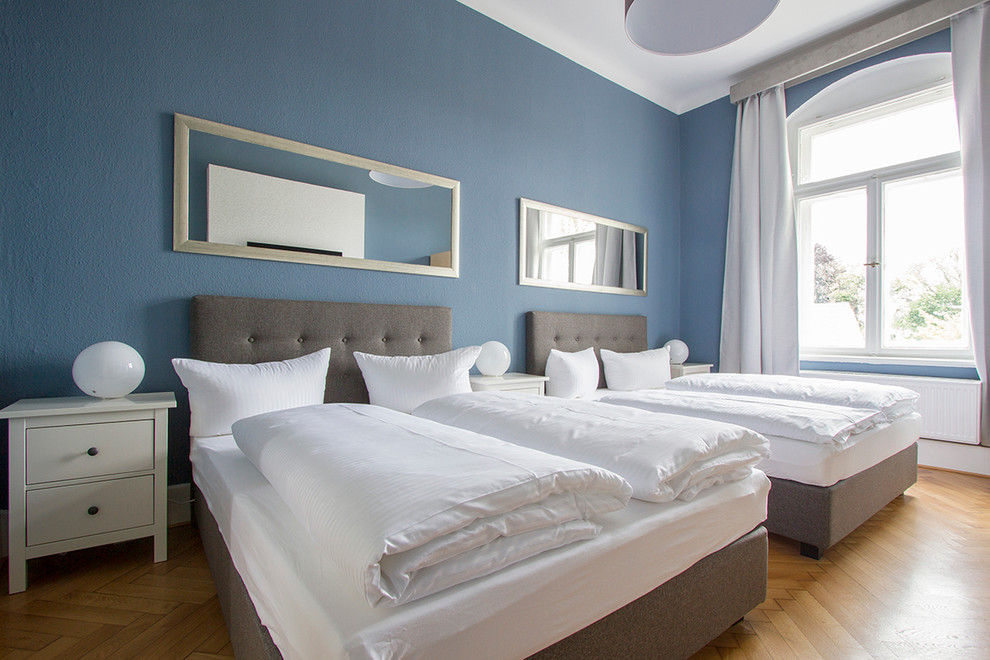 Idéer för att renovera ett stort funkis sovrum, med blå väggar och ljust trägolv