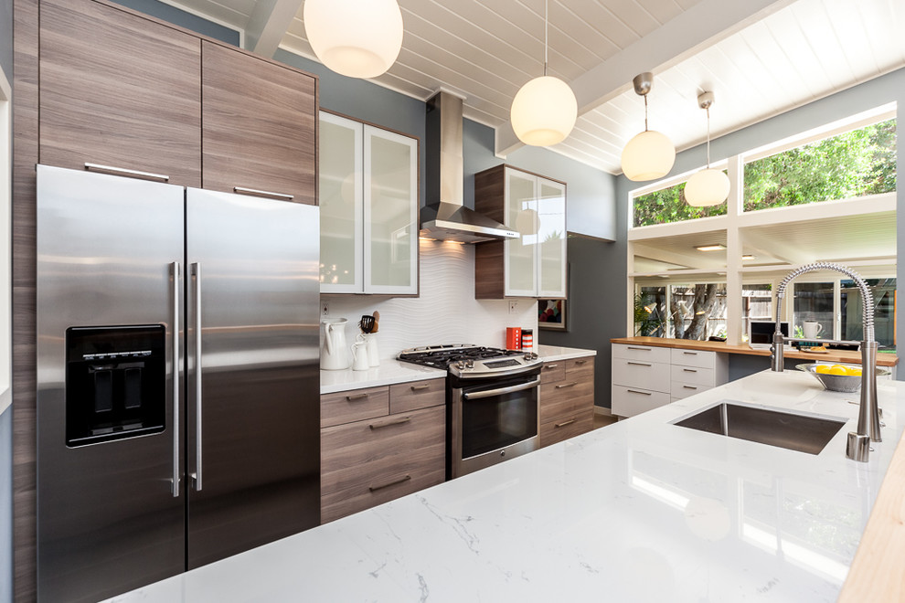 Inspiration for a small midcentury galley eat-in kitchen in Sacramento with an undermount sink, flat-panel cabinets, distressed cabinets, quartz benchtops, white splashback, ceramic splashback, stainless steel appliances and a peninsula.