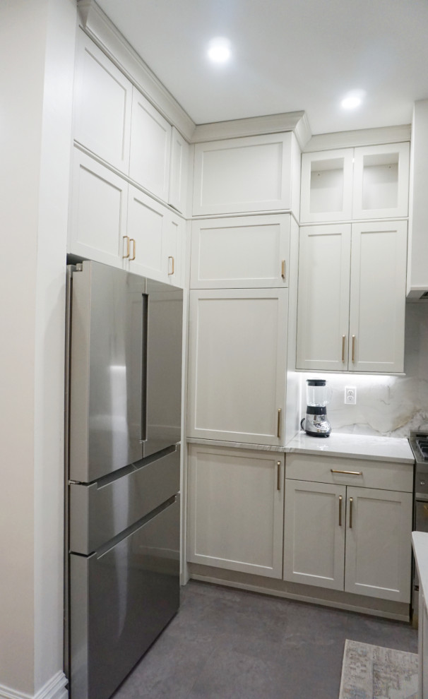 Inspiration for a transitional vinyl floor and gray floor kitchen remodel with an undermount sink, shaker cabinets, gray cabinets, quartzite countertops, stone slab backsplash, stainless steel appliances and an island
