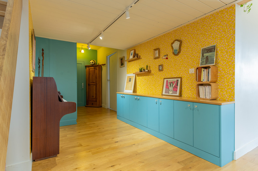 Modelo de recibidores y pasillos vintage de tamaño medio con paredes amarillas, suelo de madera clara y papel pintado