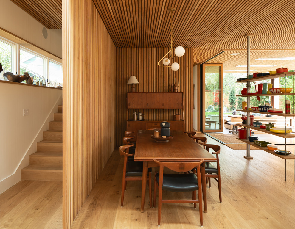 Inspiration for a midcentury open plan dining in Denver with light hardwood floors and no fireplace.