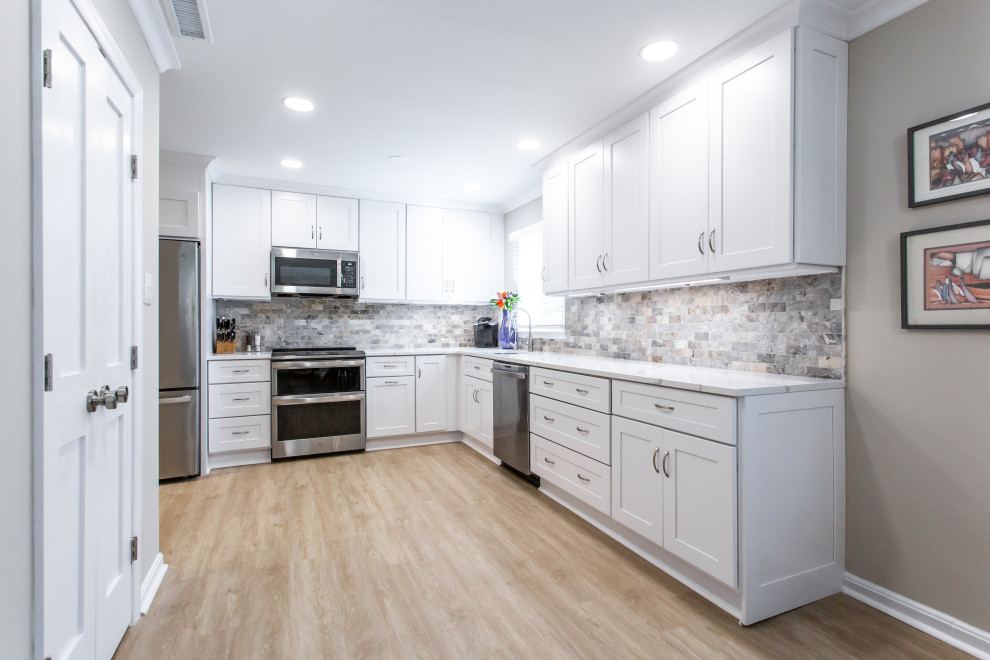 Inspiration for a mid-sized transitional l-shaped kitchen pantry in DC Metro with an undermount sink, shaker cabinets, quartz benchtops, stone tile splashback and stainless steel appliances.