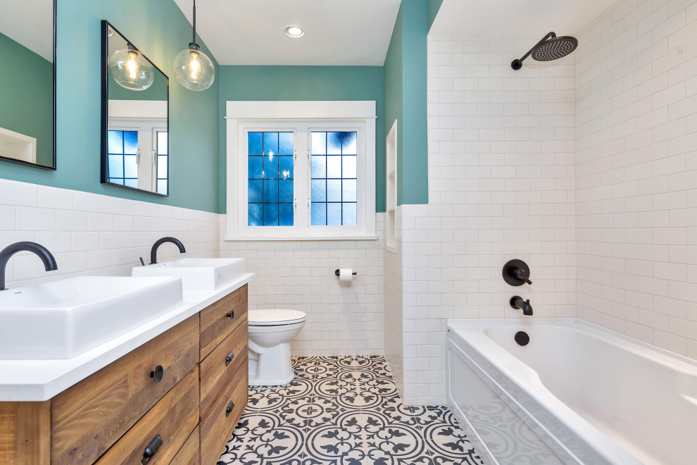 Idées déco pour une grande salle de bain classique en bois clair avec un placard en trompe-l'oeil, une baignoire posée, WC séparés, un carrelage blanc, un carrelage métro, un mur bleu, un sol en carrelage de céramique, un lavabo de ferme, un plan de toilette en quartz modifié, un sol noir, aucune cabine, une niche, meuble double vasque et meuble-lavabo sur pied.