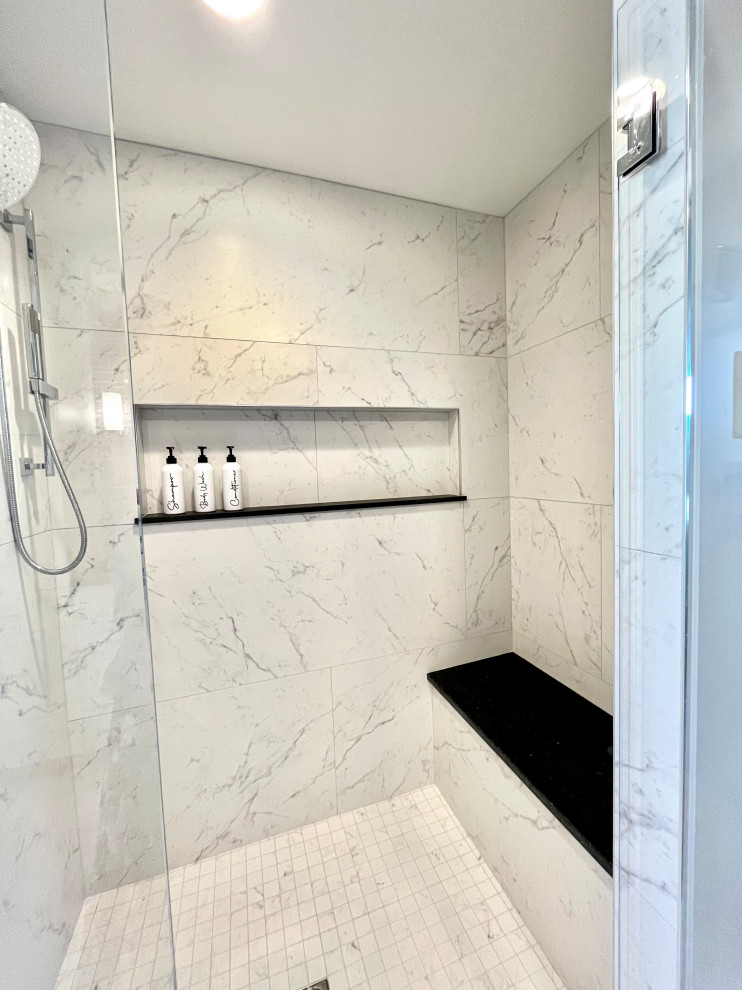 Walk-in shower - mid-sized transitional master gray tile and stone tile porcelain tile, white floor and double-sink walk-in shower idea with shaker cabinets, white cabinets, a two-piece toilet, gray walls, an undermount sink, granite countertops, a hinged shower door, black countertops and a built-in vanity